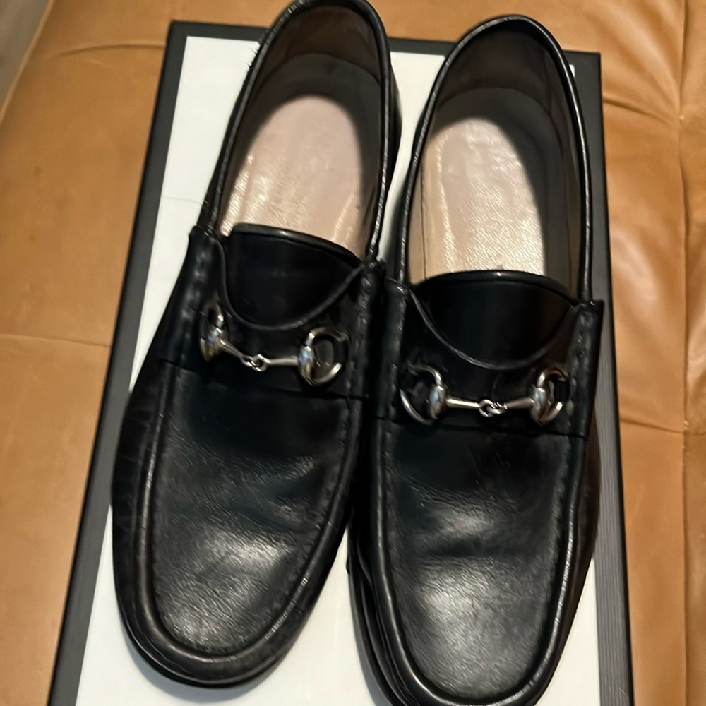 Black Gucci loafers. Silver horsebit buckle